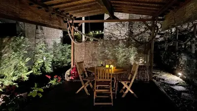 a table and chairs in a room with plants at Casas das Hortas, Studio Vista Jardim e Serra in Seixal