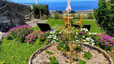a garden with flowers and a table and two chairs at Casas das Hortas, Studio Vista Jardim e Serra in Seixal