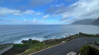 an empty road next to the ocean on a cloudy day at Casas das Hortas, Studio Vista Jardim e Serra in Seixal