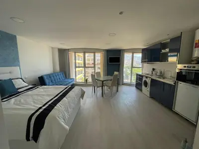 a bedroom with a bed and a table and a kitchen at Center Marina view Blue Studio in Funchal