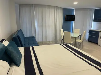 a bedroom with a large bed and a dining room at Center Marina view Blue Studio in Funchal