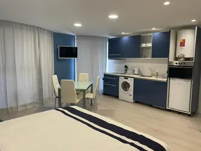 a room with a kitchen and a table with chairs at Center Marina view Blue Studio in Funchal