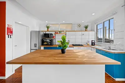 a kitchen with blue cabinets and a wooden counter top at Petit Campanário in Campanário