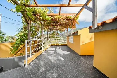 a balcony of a building with yellow walls and trees at Petit Campanário in Campanário
