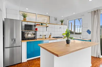 a kitchen with blue cabinets and a refrigerator at Petit Campanário in Campanário