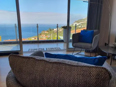 a living room with a view of the ocean at Villa Palmera Sea View in Arco da Calheta