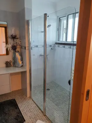 a shower with a glass door in a bathroom at Villa Palmera Sea View in Arco da Calheta
