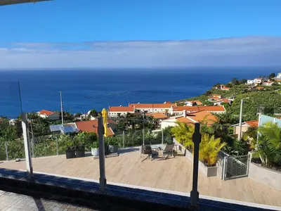 a view of a city with the ocean in the background at Villa Palmera Sea View in Arco da Calheta