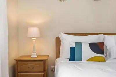 a bedroom with a bed and a lamp on a night stand at Horizon Glow in Calheta