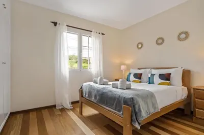 a bedroom with a large bed and a window at Horizon Glow in Calheta