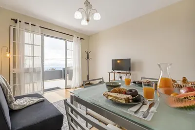 a living room with a table with food and orange juice at Horizon Glow in Calheta