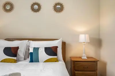 a bedroom with a bed with two mirrors on the wall at Horizon Glow in Calheta