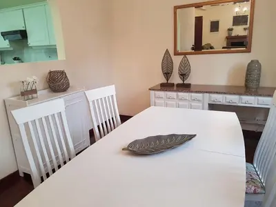 a dining room with a white table and a mirror at Villa Cosy Nook in Funchal