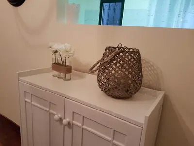 a white cabinet with a purse and flowers on it at Villa Cosy Nook in Funchal