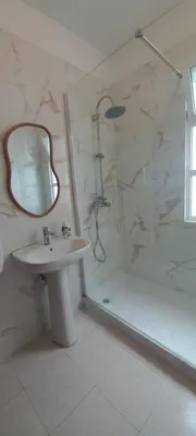 a bathroom with a sink and a shower with a mirror at Villa Cosy Nook in Funchal