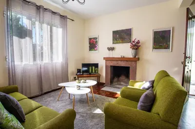 a living room with green chairs and a fireplace at Villa Cosy Nook in Funchal