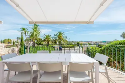 a white table and chairs on a balcony with palm trees at Casa Rosa1 at Boavista Resort in Lagos