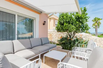 a living room with a couch and chairs on a patio at Casa Rosa1 at Boavista Resort in Lagos