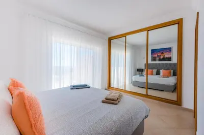 a bedroom with a bed and a large mirror at Casa Rosa1 at Boavista Resort in Lagos