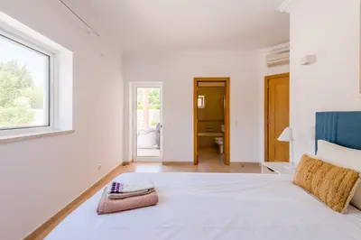 a white bedroom with a large bed and a window at Casa Rosa1 at Boavista Resort in Lagos