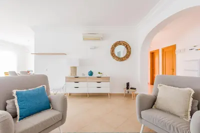 a living room with two chairs and a dresser at Casa Rosa1 at Boavista Resort in Lagos