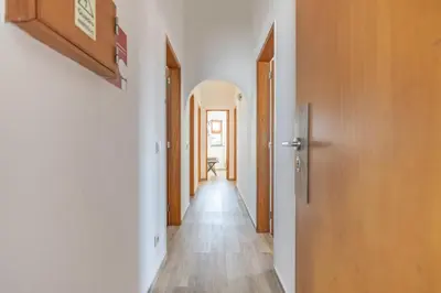 a hallway with white walls and wooden doors at Casa Calma I in Luz