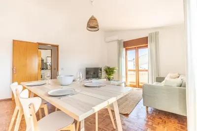 a white dining room with a table and chairs at Casa Calma I in Luz