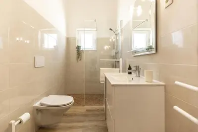 a white bathroom with a toilet and a sink at Casa Calma I in Luz