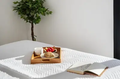 a tray of food and a cup of coffee on a bed at VIRA by KAAMAH in Estreito de Câmara de Lobos