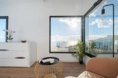 a living room with a large window and a chair at VIRA by KAAMAH in Estreito de Câmara de Lobos