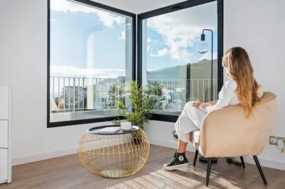a woman sitting in a chair looking out the window at VIRA by KAAMAH in Estreito de Câmara de Lobos