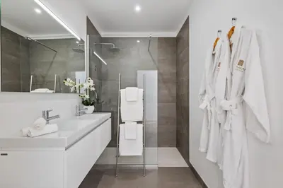 a white bathroom with a sink and a mirror at VIRA by KAAMAH in Estreito de Câmara de Lobos