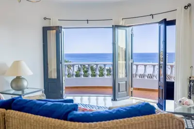 a living room with a couch and a view of the ocean at Spacious villa with sea view and heated pool - Luz - Casa Amizade in Luz