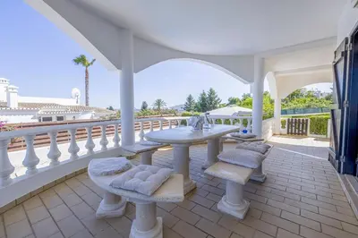 a patio with a table and chairs on a balcony at Spacious villa with sea view and heated pool - Luz - Casa Amizade in Luz