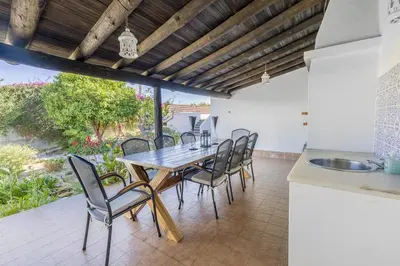 a kitchen and dining room with a wooden table and chairs at Spacious villa with sea view and heated pool - Luz - Casa Amizade in Luz