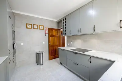 a kitchen with white cabinets and a wooden door at Spacious villa with sea view and heated pool - Luz - Casa Amizade in Luz