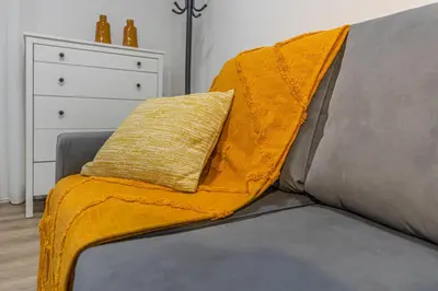 a yellow blanket sitting on top of a couch at Vila Sun House AB in Calheta
