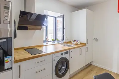 a kitchen with a sink and a washing machine at Vila Sun House AB in Calheta