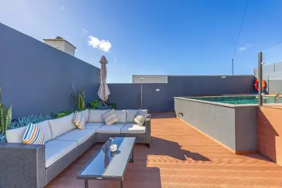 a patio with a couch and a swimming pool at Vila Sun House AB in Calheta