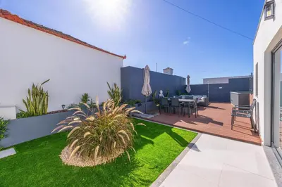 a garden with a patio with a table and chairs at Vila Sun House AB in Calheta