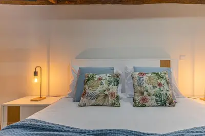 a white bed with two pillows on top of it at Vila Sun House A in Calheta
