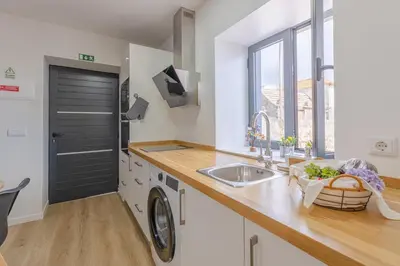 a kitchen with a sink and a washing machine at Vila Sun House A in Calheta