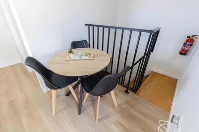 a table and chairs in a room with a staircase at Vila Sun House A in Calheta