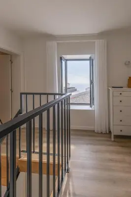 a room with a staircase with a window and a dresser at Vila Sun House B in Calheta