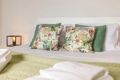 a bed with four pillows on top of it at Vila Sun House B in Calheta
