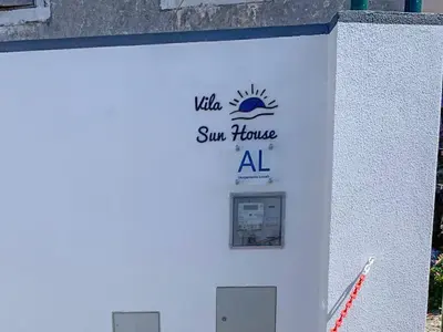 a sign on the side of a building with a sun house al sign at Vila Sun House B in Calheta