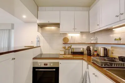 a white kitchen with white cabinets and a sink at Vista Formosa in Funchal