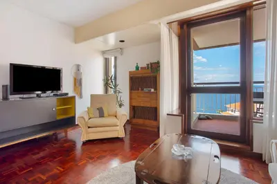 a living room with a large window and a television at Vista Formosa in Funchal