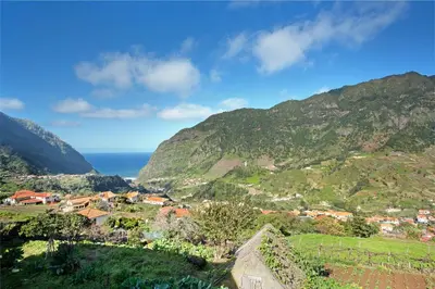 a village on a hill with the ocean in the background at Cristina Grand in São Vicente