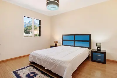 a bedroom with a large bed and two windows at Cristina Grand in São Vicente